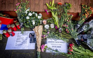 A photograph taken outside Russia's embassy in The Hague on March 23, 2024, shows bunches of flowers displayed at a makeshift memorial, a day after a gun attack in Krasnogorsk, outside Moscow. Camouflaged assailants opened fire at the packed Crocus City Hall in Moscow's northern suburb of Krasnogorsk on March 22, 2024, evening ahead of a concert by Soviet-era rock band Piknik in the deadliest attack in Russia for at least a decade. Russia on March 23, 2024, said it had arrested 11 people - including four gunmen - over the attack on a Moscow concert hall claimed by Islamic State, as the death toll rose to over 130 people. (Photo by Robin Utrecht / ANP / AFP) / Netherlands OUT (Photo by ROBIN UTRECHT/ANP/AFP via Getty Images)
