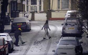 epa11806702 Young people play with snow in Walthamstow, east London, Britain, in the early hours of 05 January 2025. Multiple weather warnings have been issued as Britain and Ireland grapple with travel disruptions and power cuts following days of harsh winter weather with heavy snow fall and icy conditions.  EPA/TOLGA AKMEN