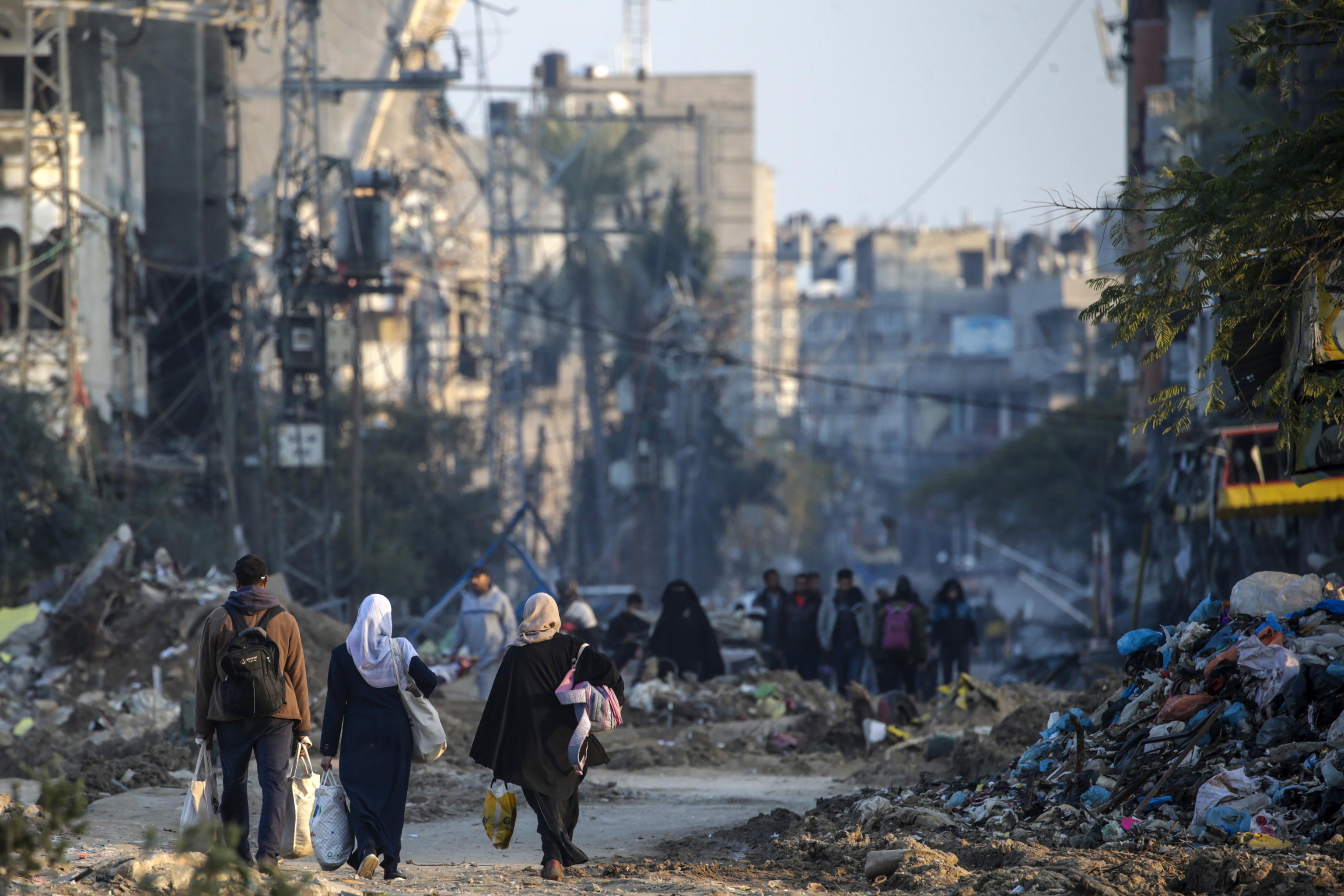 epa11090413 People walk among destroyed houses and buildings during Isreali military operation in Al Maghazi refugee camps in southern Gaza Strip, 19 January 2024. More than 24,400 Palestinians and at least 1,300 Israelis have been killed, according to the Palestinian Health Ministry and the Israel Defense Forces (IDF), since Hamas militants launched an attack against Israel from the Gaza Strip on 07 October, and the Israeli operations in Gaza and the West Bank which followed it. Since 07 October, up to 1.9 million people, or more than 85 percent of the population, have been displaced throughout the Gaza Strip, some more than once, according to the United Nations Relief and Works Agency for Palestine Refugees in the Near East (UNRWA), which added that most civilians in Gaza are in 'desperate need of humanitarian assistance and protection.  EPA/MOHAMMED SABER