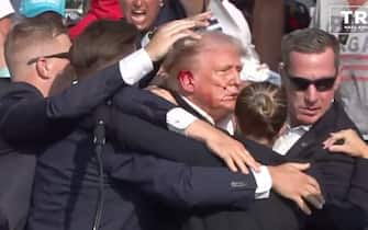 BUTLER, PENNSYLVANIA, UNITED STATES - JULY 13: (----EDITORIAL USE ONLY - MANDATORY CREDIT - 'TRUMP CAMPAIGN OFFICE / HANDOUT' - NO MARKETING NO ADVERTISING CAMPAIGNS - DISTRIBUTED AS A SERVICE TO CLIENTS----) A screen grab captured from a video shows Republican presidential candidate former President Donald Trump appears to be injured after gunshots were reported as he is rushed offstage during a rally on July 13, 2024 in Butler, Pennsylvania. Trump was seen bloodied on his right ear as he was being evacuated from the stage, according to social media footage. (Photo by Trump Campaign Office / Handout/Anadolu via Getty Images)