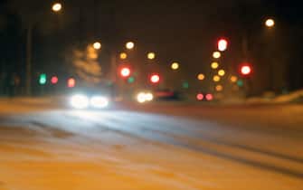 Cars on the winter road with snow. Dangerous car traffic in bad weather with bokeh at night to use background