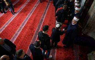 Muslim devotees pay respect to Imams after offering prayers for Eid al-Fitr which marks the end of the holy fasting month of Ramadan, at the Grand Mosque of Pristina on March 30, 2025. (Photo by Armend NIMANI / AFP)