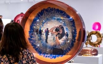 Costa Mesa, CA - October 08: A woman takes a photo as visitors explore the exhibition, Fred Eversley: Reflecting Back (the World), at the Orange County Museum of Art in Costa Mesa late Saturday evening, October 8, 2022, during the museums 24-hour grand opening celebration.  (Photo by Mark Rightmire/MediaNews Group/Orange County Register via Getty Images)