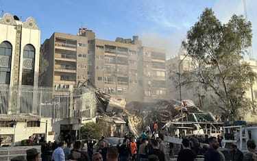 Emergency and security personnel gather at the site of strikes which hit a building adjacent to the Iranian embassy in Syria's cpital Damascus, on April 1, 2024. Israeli strikes hit Syria's capital on April 1, state media reported, as a war monitor said six people were killed in a building adjacent to the Iranian embassy. (Photo by Maher AL MOUNES / AFP)