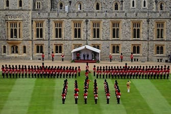 US President Joe Biden and Britain's King Charles III on the dais, listen to the US National Anthem played by the Band of the Welsh Guards, during a ceremonial welcome in the Quadrangle at Windsor Castle in Windsor on July 10, 2023. US President Joe Biden was in Britain on Monday, where he met with Prime Minister Rishi Sunak and King Charles III, before going on to a NATO summit in Lithuania. (Photo by Ben Stansall / POOL / AFP) (Photo by BEN STANSALL/POOL/AFP via Getty Images)