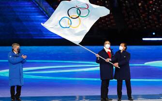 epa09774121 Milan Mayor Giuseppe Sala and his Cortina dâ€™Ampezzo counterpart Gianpietro Ghedina wave the Olympic Flag next to International Olympic Committee (IOC) President Thomas Bach (L) during the Closing Ceremony for the Beijing 2022 Olympic Games at the National Stadium, also known as Bird's Nest, in Beijing China, 20 February 2022.  EPA/ROMAN PILIPEY