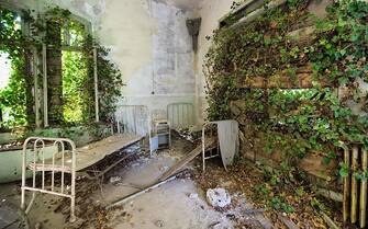 VENICE, ITALY - AUGUST 27:   Beds and furniture remain in one of the dormitories in the psychiatric ward of the abandoned Hospital of Poveglia on August 27, 2011 in Venice, Italy. The island of Poveglia, with its ruined hospital and plague burial grounds, is said to be the most haunted location in the world. The area is located within a multi-million dollar piece of real estate but is deserted and off limits to the public. The dark and derelict forbidding shores are only minutes away from the glamour of the Venice Film Festival on the Lido.  (Photo by Marco Secchi/Getty Images)