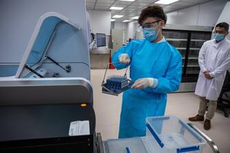 epa08981073 A lab technician demonstrates testing equipment for SARS-CoV-2 at the Temporary North Lantau Hospital Hong Kong Infection Control Centre in Tung Chung, Hong Kong, China, 02 February 2021. The temporary hospital, scheduled to open in February 2021, comprises six ward blocks and a medical centre. The facility is equipped with a negative pressure ward that can accommodate more than 820 beds and related medical facilities. The novel coronavirus SARS-COV-2, which causes the COVID-19 disease, has been recognized as a pandemic by the World Health Organization (WHO) on 11 March 2020.  EPA/JEROME FAVRE