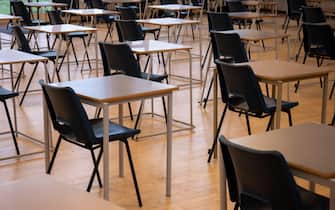 School chairs and tables set up for exams in a school hall. Early morning preparation for examinations in an exam room