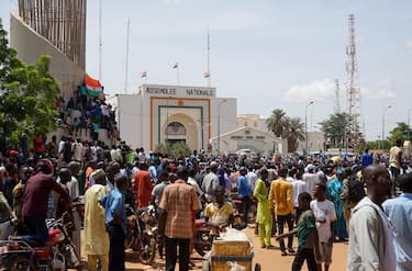epa10777417 People gather outside the National Assembly building during a protest in Niamey, Niger, 30 July 2023. Thousands of supporters of General Abdourahamane Tchiani, head of the Presidential Guard, who declared himself the new leader of Niger after a coup against democratically elected President Mohamed Bazoum on 26 July, took to the streets of Niamey to demonstrate support for the coup.  EPA/ISSIFOU DJIBO