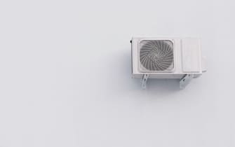 Outdoor air conditioner split system unit on white wall with copy space