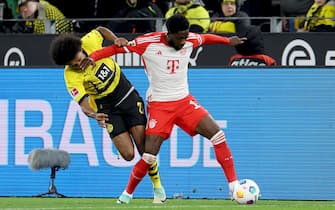 epa10958240 Dortmund s Karim Adeyemi (L) in action against Munich's Alphonso Davies (R) during the German Bundesliga soccer match between Borussia Dortmund and FC Bayern Munich in Dortmund, Germany, 04 November 2023.  EPA/CHRISTOPHER NEUNDORF CONDITIONS - ATTENTION: The DFL regulations prohibit any use of photographs as image sequences and/or quasi-video.