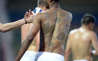 Wolfsburg's Brazilian defender Naldo shakes hands and shows the tattoo on his back, the Cruzifixion, at the end of the first round DFB football match Karlsruher SC vs VfL Wolfsburg on August 3, 2013 in Karlsruhe, southern Germany. 
AFP PHOTO / DPA/ ULI DECK   GERMANY OUT        (Photo credit should read ULI DECK/DPA/AFP via Getty Images)