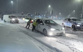 People help to push cars stuck in snow in Leeds, Yorkshire. Heavy overnight snow is causing disruption across the UK as the cold start to the new year continues. Picture date: Sunday January 5, 2025.