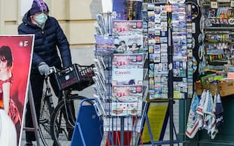 Un uomo con la mascherina in bicicletta davanti ad una edicola di piazza Castello, Torino, 28 febbraio 2020. ANSA/ TINO ROMANO
