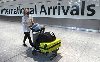(FILES) In this file photo taken on July 10, 2020, a passenger wearing a face covering due to the COVID-19 pandemic, arrives at Heathrow airport, west London. - Britain will ban all arrivals from South American countries and Portugal from 0400 GMT Friday, January 15 over fears of importing a new coronavirus variant in Brazil, Transport Secretary Grant Shapps said Thursday. (Photo by DANIEL LEAL-OLIVAS / AFP)