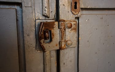 Rusty padlock, shoot by sunlight in Italy. The door is paint in gray