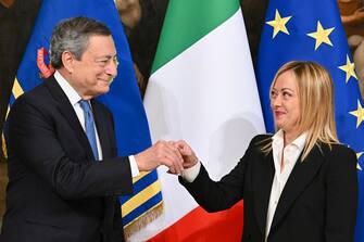 Italy's new Prime Minister Giorgia Meloni (R) receives a small bell by outgoing Prime Minister Mario Draghi to mark the government handover and to open the first council of Ministers at Chigi Palace in Rome, Italy, 23 October 2022. ANSA/ETTORE FERRARI