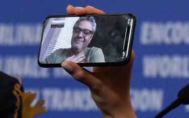 TOPSHOT - Iranian actress Baran Rasoulof holds a phone displaying Iranian director Mohammad Rasoulof who was awarded the "Golden Bear for Best Film" attends a press conference after the awarding ceremony of the 70th Berlinale film festival in Berlin on February 29, 2020. (Photo by John MACDOUGALL / AFP) (Photo by JOHN MACDOUGALL/AFP via Getty Images)