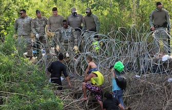 epa10621089 Soldiers observe migrants after crossing the Rio Grande to try to enter the United States, in Matamoros, Mexico, 10 May 2023 (issued 11 May 2023). On the last day of Title 42 policy, migrants have attempted to cross into the United States.  EPA/Abraham Pineda Jácome
