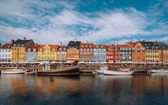 Scenic view of Nyhavn pier with color buildings, ships, yachts and other boats in the Old Town of Copenhagen, Denmark.