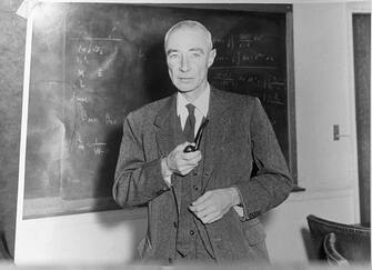 (Original Caption) Robert Oppenheimer (1904-1967), American physicist, Director of the Manhattan project. Undated photograph, standing before blackboard, holding pipe.