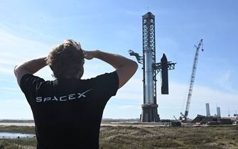 TOPSHOT - A person looks on as SpaceX's huge Super Heavy-Starship is unstacked from the booster as it sits on the launchpad at Starbase in Boca Chica, Texas, on November 16, 2023, ahead of its second test flight posponed to November 18. The US Federal Aviation Administration (FAA) on November 15, 2023 authorized SpaceX to carry out its second launch of Starship, the most powerful rocket ever built, after a first attempt in April ended in a spectacular explosion. (Photo by TIMOTHY A. CLARY / AFP) (Photo by TIMOTHY A. CLARY/AFP via Getty Images)