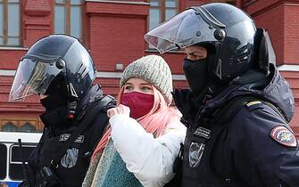 Una manifestante russa portata via dalla polizia