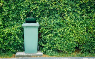 Trash bin garbage waste cabinet place outdoor around green plant with space for text for eco clean city recycle for nature concept