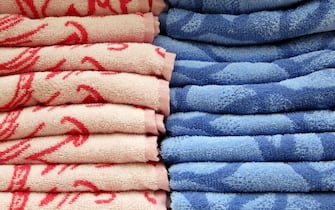 Stack of colorful terry towels. Soft background, pink and blue bath textile close up
