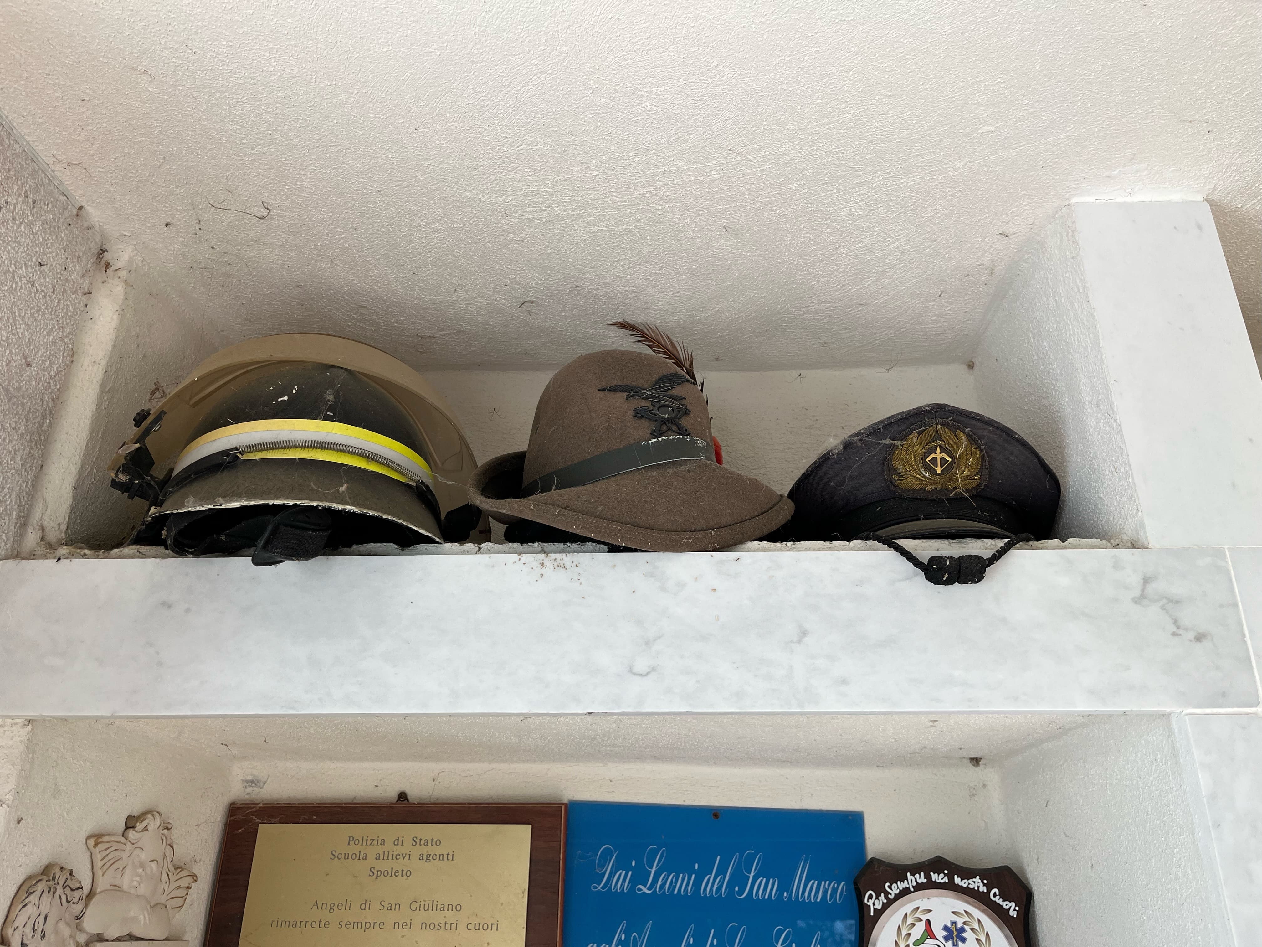 I cappelli dei soccorritori nel cimitero di San Giuliano