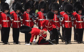 A member of the Grenadier Guards stands up after fainting during the Colonel's Review at Horse Guards Parade in London on June 10, 2023 ahead of The King's Birthday Parade. The Colonel's Review is the final evaluation of the parade before it goes before Britain's King Charles III during the Trooping of the Colour on June 17. (Photo by Adrian DENNIS / AFP) (Photo by ADRIAN DENNIS/AFP via Getty Images)