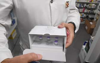 Un farmacista prende dal frigorifero una scatola che continene le dosi di Pfizer in una farmacia di Milano, 10 novembre 2021. ANSA/DANIEL DAL ZENNARO

