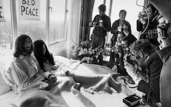 Beatles member John Lennon (L) and his wife Yoko Ono receive journalists 25 March 1969 in the bedroom of the Hilton hotel in Amsterdam, during their honeymoon in Europe. AFP / ANP PHOTO (Photo credit should read /AFP via Getty Images)