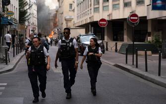 French police officers walk after a building partly collapsed at Place Alphonse-Laveran in the 5th arrondissement of Paris, on June 21, 2023. A major fire broke out on June 21, 2023 in a building in central Paris, part of which collapsed, according to images taken by AFP journalists. (Photo by ABDULMONAM EASSA / AFP) (Photo by ABDULMONAM EASSA/AFP via Getty Images)