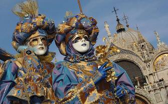 VENICE, ITALY - FEBRUARY 23: Traditionaly masked Venetians pose on San Marco square during the Carnival February 23, 2006 in Venice, Italy. The Carnival traditionally celebrates the passing of winter with parties, balls and costumes in the run-up to the Christian observation of Lent. (Photo by Franco Origlia/Getty Images)