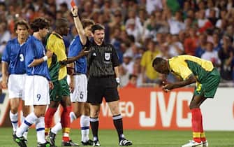 Australia referee Edward Lennie (Center L) takes out a red card to send off Cameroon's Raymond Kalla Nkongo (R) two minutes before halftime, 17 June at the Stade de la Mosson in Montpellier during the 1998 Soccer World Cup Group B first round match between Italy and Cameroon. Italy leads 2-0. (ELECTRONIC IMAGE) AFP PHOTO GERARD JULIEN (Photo by GERARD JULIEN / AFP)        (Photo credit should read GERARD JULIEN/AFP via Getty Images)