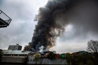 epa10566217 Smoke rises from a fire burning at a warehouse in the Rothenburgsort district of Hamburg, Germany, 09 April 2023. Residents have been warned of heavy smoke and possible toxins in the air. An alert issued by the Hamburg fire department said smoke gasses and chemical components in the air could affect breathing.  EPA/DOMINICK WALDECK