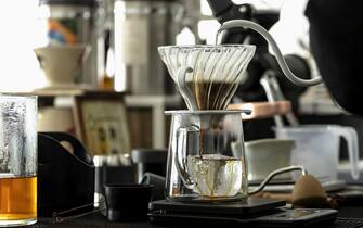 Drip coffee, pouring water on coffee ground with filter using a pour-over technique