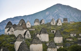 OSSETIA, RUSSIA - AUGUST 16: A view of the largest necropolis of the Caucasus located on a green hill, strewn with many tiny crypts, where residents buried their family members in them, in Dargavs, Ossetia, Russia on August 16, 2022. In total, there are about 97 crypts in Dargavs, which is under protection of UNESCO. (Photo by Alexander Manzyuk/Anadolu Agency via Getty Images)