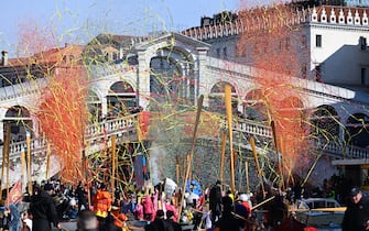 Confettis explode as decorated boats sail on the Grand Canal in front of Rialto bridge during Venice Carnival, on February 16, 2025. This year, the theme of one of the most famous carnival in the world is Casanova, as the 'Serenissima' celebrates the 300th anniversary of the famous man's birth. (Photo by ANDREA PATTARO / AFP)