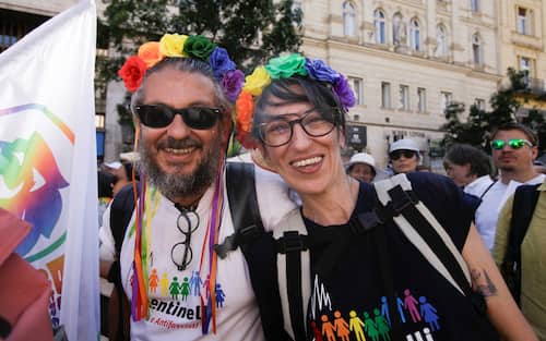People pose for a photographer as they take part in the Budapest Pride parade in Budapest downtown on June 28, 2025, as the capital's municipality organised this march by the LGBTQ community, celebrating freedom, in a move to circumvent a law that allows police to ban LGBTQ marches. Hungary's Prime Minister had announced that police will not "break up" Saturday's Budapest Pride march despite issuing a ban, but warned attendees and organisers about the legal consequences. His ruling coalition amended laws and the constitution earlier this year to prohibit the annual celebration, advancing his widely condemned, years-long clampdown on LGBTQ rights in the name of "child protection". (Photo by Peter Kohalmi / AFP)