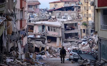 A Turkish soldier walks among destroyed buildings in Hatay, on February 12, 2023, after a 7.8-magnitude earthquake struck the country's south-east. - The death toll from a massive earthquake that hit Turkey and Syria climbed to more than 20,000 on February 9, 2023, as hopes faded of finding survivors stuck under rubble in freezing weather. (Photo by Yasin AKGUL / AFP) (Photo by YASIN AKGUL/AFP via Getty Images)