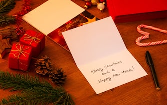 Handwritten Christmas Card, just signed with a marker. Stack of other cards and envelopes in the background. Photo on front of the card is mine.