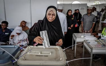 A voter casts her ballot while others queue at the Maundi voting centre in Stone Town on October 29, 2025, during Tanzania's presidential elections. Polls opened on October 29, 2025 in Tanzania elections in which the main challengers were either jailed or barred from running, with rights groups decrying a "wave of terror".
President Samia Suluhu Hassan, 65, is determined to cement her position with an emphatic victory that will silence critics within her own party, analysts say. (Photo by Marco Longari / AFP)