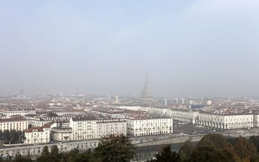 Daytime panorama of the city of Turin, Italy, in a foggy day. River Po is in the foreground, Mole Antonelliana (iconic monument of the city) can be barely seen.