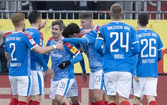 30 January 2021, Schleswig-Holstein, Kiel: Football: 2. Bundesliga, Holstein Kiel - Eintracht Braunschweig, Matchday 19. Kiel's players celebrate Kiel's Fin Bartels (3rd from left) for his goal to make it 2:0. Photo: Axel Heimken/dpa - IMPORTANT NOTE: In accordance with the regulations of the DFL Deutsche FuÃŸball Liga and/or the DFB Deutscher FuÃŸball-Bund, it is prohibited to use or have used photographs taken in the stadium and/or of the match in the form of sequence pictures and/or video-like photo series.