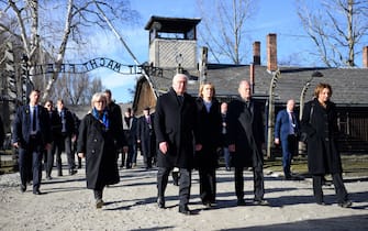 27 January 2025, Poland, Oswiecim: Federal President Frank-Walter Steinmeier (4th from right) and his wife Elke Büdenbender (3rd from right) walk together with Federal Chancellor Olaf Scholz (2nd from right, SPD) and his wife Britta Ernst (right) through the gate of the former German concentration and extermination camp Auschwitz-Birkenau, Auschwitz I main camp, with the inscription "Arbeit macht frei" ("Work sets you free"). Federal President Steinmeier and Federal Chancellor Scholz take part in the commemoration of the 80th anniversary of the liberation of the former German concentration and extermination camp Auschwitz with a high-ranking delegation. Delegations from numerous countries will attend the ceremony at the Auschwitz memorial site. On January 27, 1945, Soviet soldiers liberated the German extermination camp Auschwitz in Wehrmacht-occupied Poland. Photo: Bernd von Jutrczenka/dpa (Photo by Bernd von Jutrczenka/picture alliance via Getty Images)