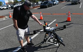 CLERMONT, FLORIDA, UNITED STATES - MARCH 30: DroneUp hub leader Darby Nethercutt points to the yellow parachute on a delivery drone at the DroneUp hub in the parking lot at the Walmart Supercenter in Clermont, Florida, United States on March 30, 2023. Walmart customers who live within one mile of the store can have certain items weighing up to 10 pounds delivered to their home by drone within 30 minutes for a $3.99 fee. (Photo by Paul Hennesy/Anadolu Agency via Getty Images)