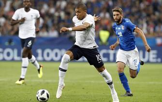 epa06779195 Kylian Mbappe of France (L) in action against Domenico Berardi of Italy (R) during the International Friendly soccer match between France and Italy in Nice, France, 01 June 2018.  EPA/SEBASTIEN NOGIER